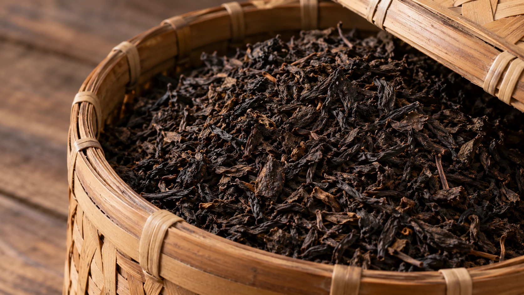 Dark fermented tea leaves in an unmarked woven basket, illustrating Liu Bao.