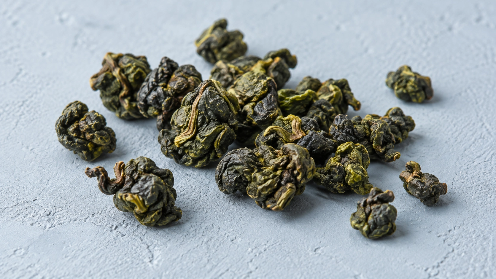 AI-generated editorial illustration: Tightly rolled oolong-style tea pellets on light slate; Jin Xuan cultivar unverified