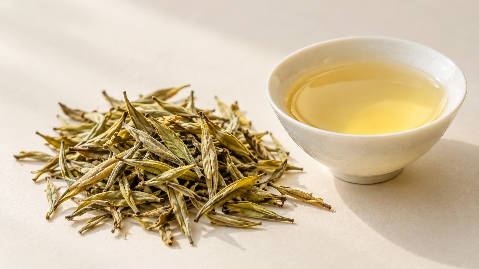 AI-generated editorial illustration: Pale yellow brewed tea beside long, light-colored tea leaves on a light stone background; tea processing style unverified